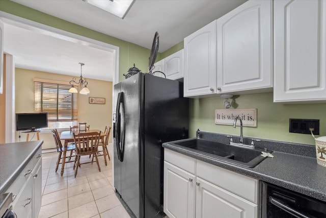 kitchen featuring dark countertops, white cabinets, black appliances, and a sink