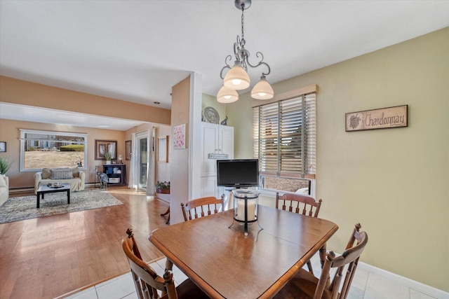 dining space featuring light tile patterned flooring and baseboards