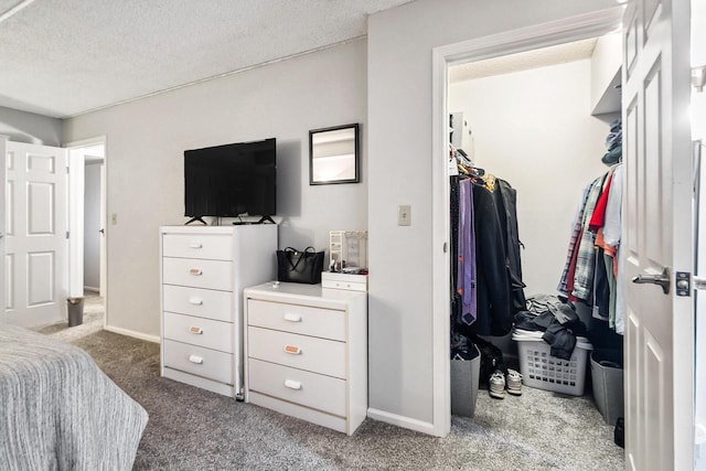 bedroom with baseboards, carpet floors, and a textured ceiling