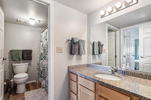 full bathroom with visible vents, toilet, vanity, and wood finished floors