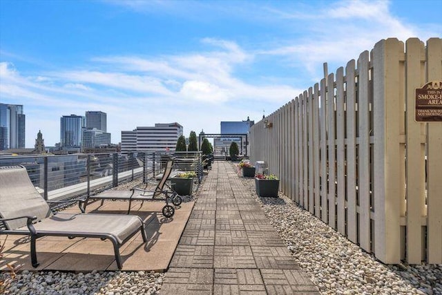 view of patio with a view of city and fence