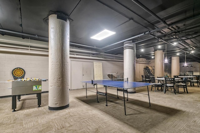 game room featuring concrete block wall and carpet flooring