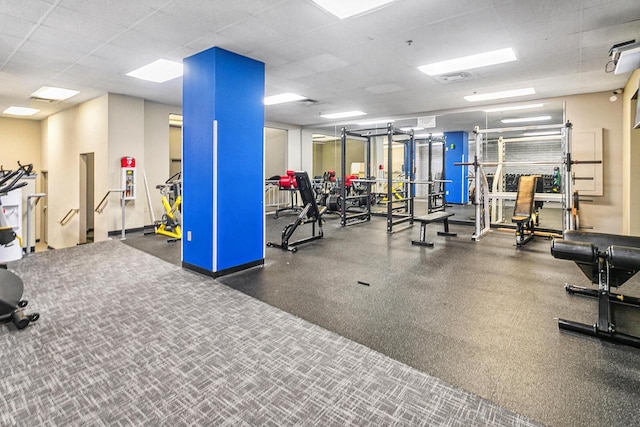 gym with a paneled ceiling