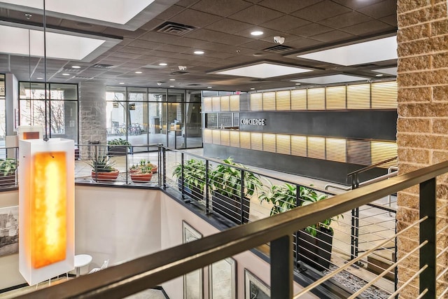 hall featuring visible vents and a paneled ceiling