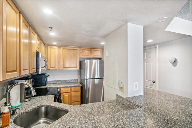 kitchen featuring a sink, recessed lighting, stone countertops, and stainless steel appliances