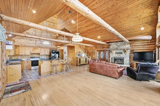 living area featuring beamed ceiling, high vaulted ceiling, wood ceiling, and light wood-style flooring