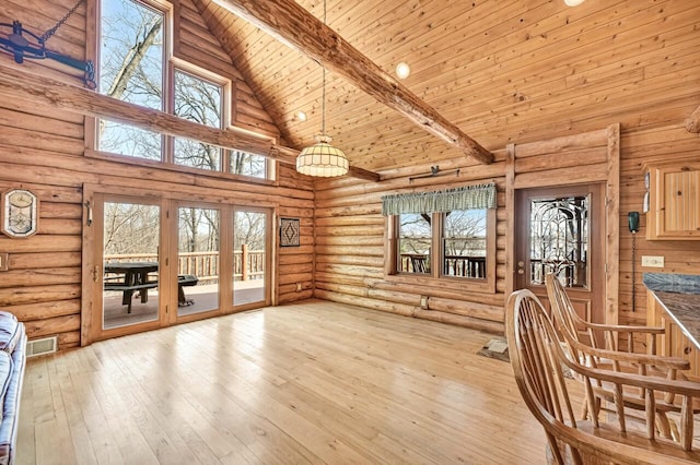 unfurnished dining area featuring light wood finished floors, visible vents, wood ceiling, rustic walls, and high vaulted ceiling