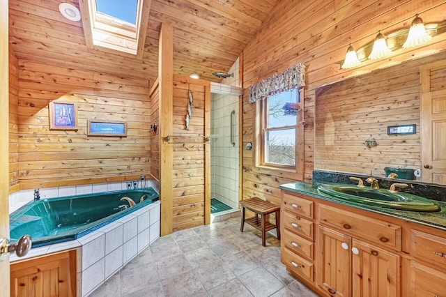 bathroom with a garden tub, a tile shower, vaulted ceiling with skylight, wooden walls, and vanity