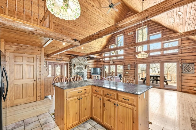 kitchen with dark countertops, beamed ceiling, a fireplace, and wood ceiling