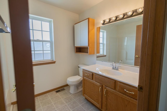 bathroom featuring vanity, baseboards, visible vents, tile patterned flooring, and toilet