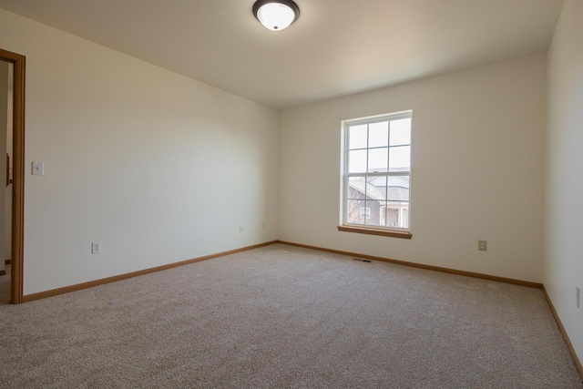 unfurnished room featuring visible vents, baseboards, and light colored carpet