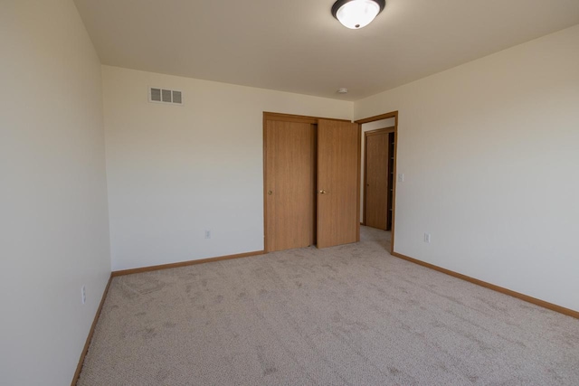 unfurnished room featuring visible vents, light carpet, and baseboards