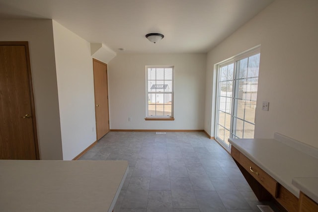 unfurnished dining area featuring baseboards