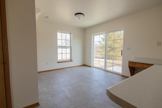 unfurnished dining area with baseboards