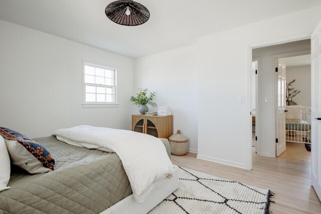 bedroom featuring baseboards and light wood finished floors