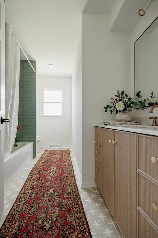 bathroom with vanity, shower / bathtub combination with curtain, baseboards, visible vents, and toilet