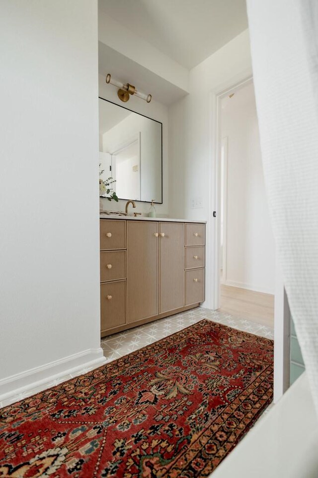 bathroom with tile patterned floors, baseboards, and vanity