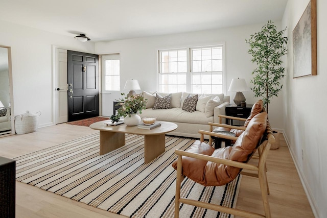 living area with baseboards and light wood-style flooring