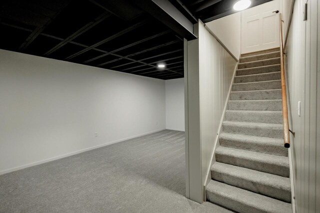 stairs featuring baseboards and carpet flooring