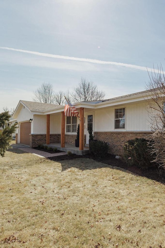 ranch-style house with brick siding, a front lawn, and a garage