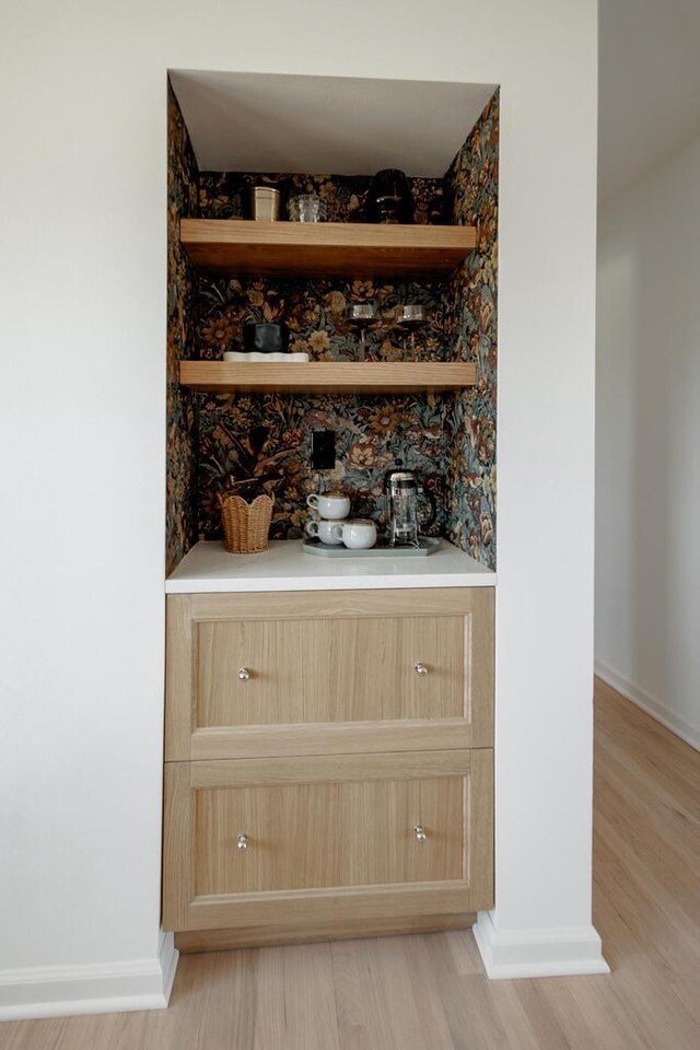 bar featuring baseboards and light wood-style flooring