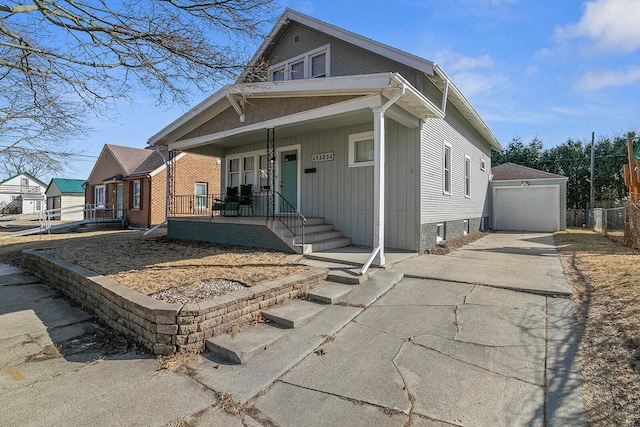 bungalow-style home with a garage, an outbuilding, covered porch, and driveway