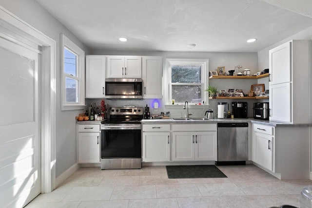 kitchen featuring a sink, open shelves, white cabinetry, and stainless steel appliances