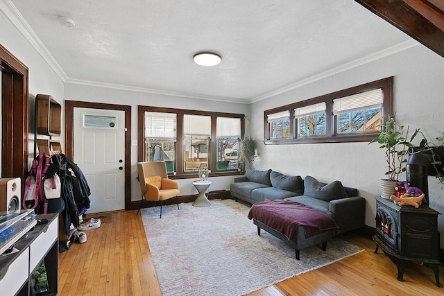 living room with light wood-style flooring, a wood stove, and ornamental molding