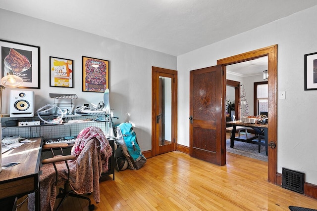 office space with light wood-style flooring, baseboards, and visible vents