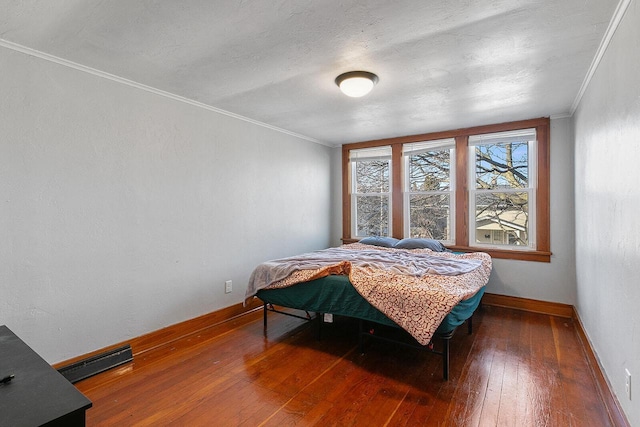 bedroom featuring visible vents, crown molding, baseboards, and hardwood / wood-style flooring