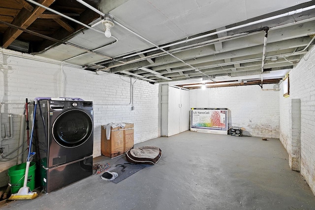 unfinished basement with brick wall and washer / clothes dryer