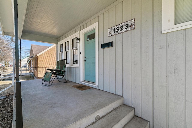 view of exterior entry featuring board and batten siding and covered porch