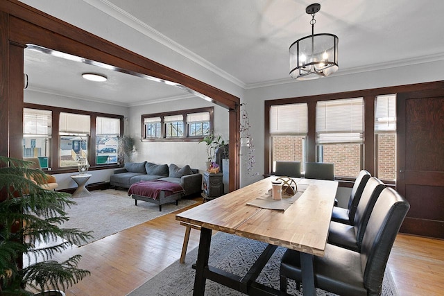 dining room featuring light wood-style floors, a chandelier, and ornamental molding