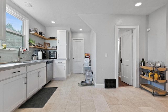 kitchen with dishwasher, white cabinetry, open shelves, and a sink