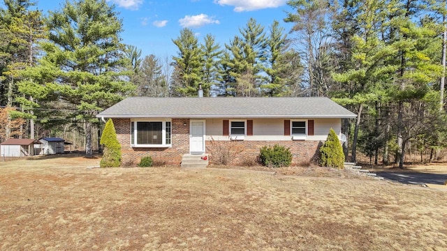 single story home featuring brick siding and a front yard