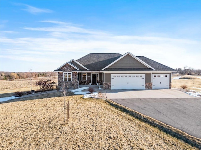 view of front of house with a garage, stone siding, and driveway