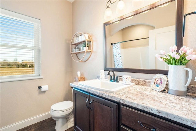 bathroom featuring toilet, wood finished floors, a shower with shower curtain, baseboards, and vanity