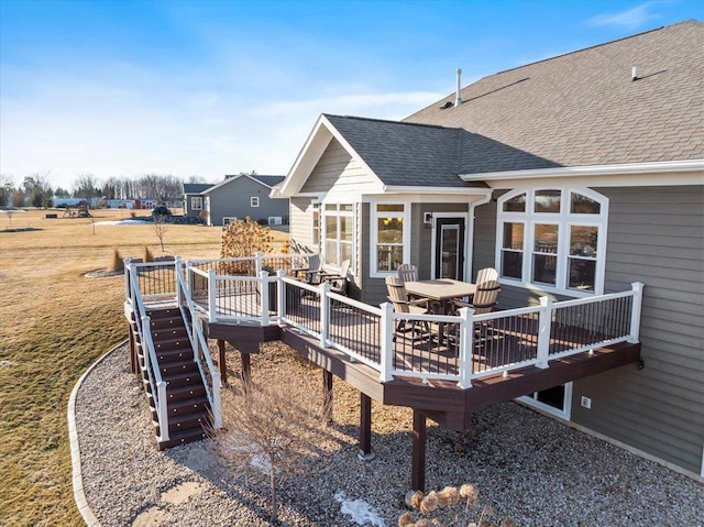 exterior space featuring outdoor dining space, a shingled roof, and a deck