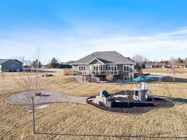 back of property featuring a deck, a playground, and stairs