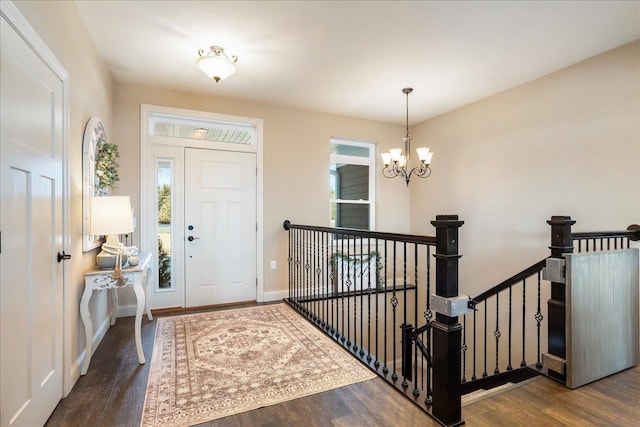 entryway featuring wood finished floors, baseboards, and a chandelier