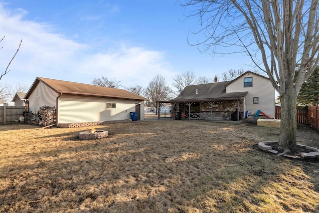 back of house with an outdoor fire pit and a fenced backyard