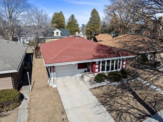 view of front of home featuring a garage, driveway, and a shingled roof