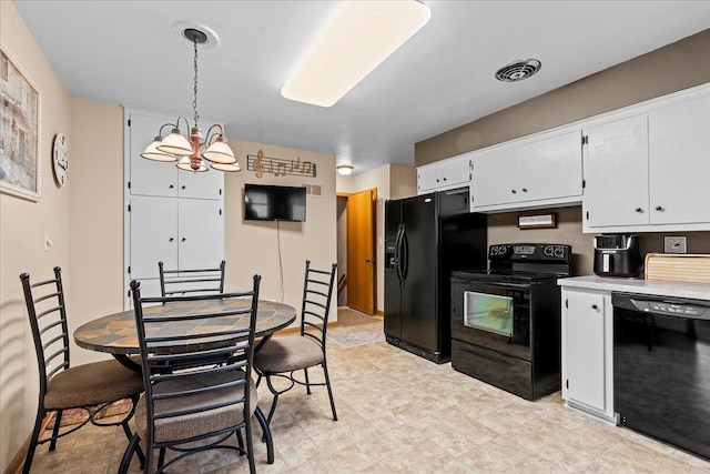 kitchen with visible vents, black appliances, white cabinets, light countertops, and decorative light fixtures