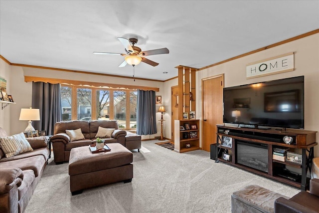 living room with carpet flooring, baseboards, a ceiling fan, and ornamental molding