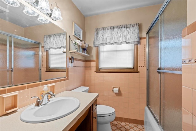 full bathroom with vanity, toilet, plenty of natural light, and tile walls