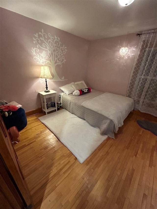 bedroom featuring baseboards and wood-type flooring