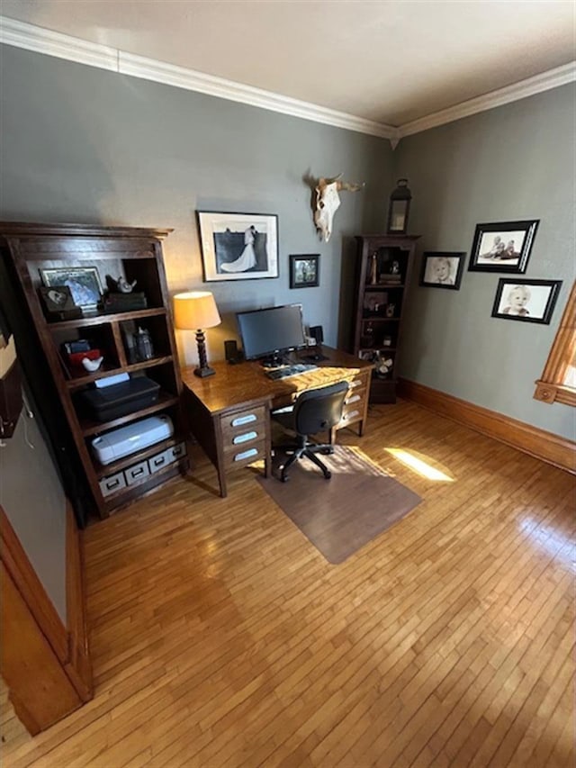 home office with crown molding, light wood-type flooring, and baseboards