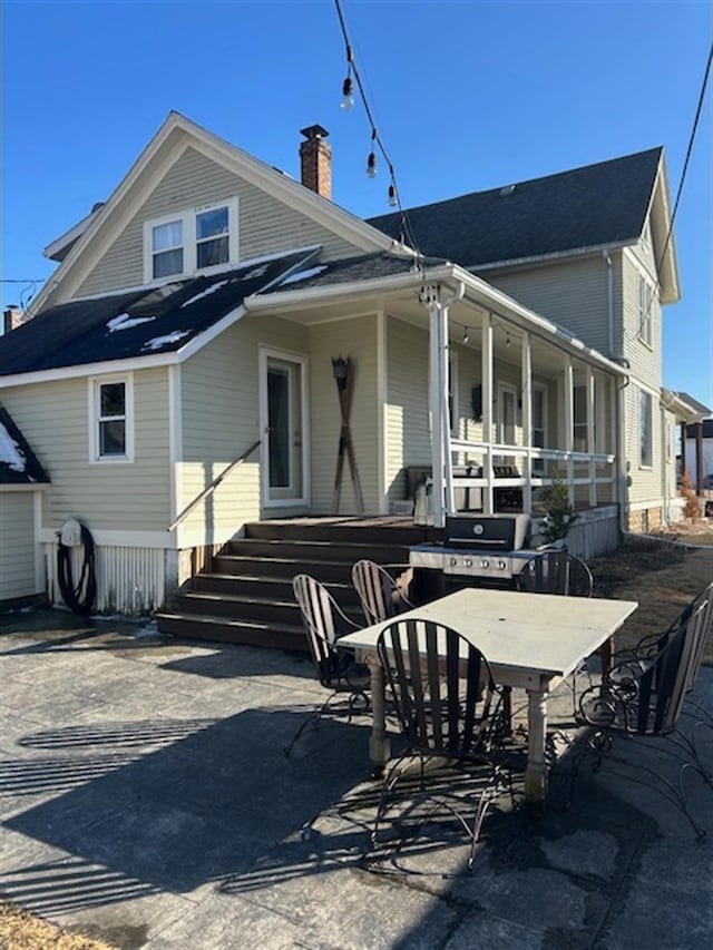 back of house featuring a chimney and a patio