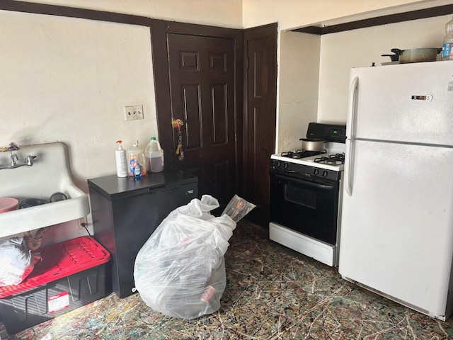 kitchen with range with gas stovetop and freestanding refrigerator