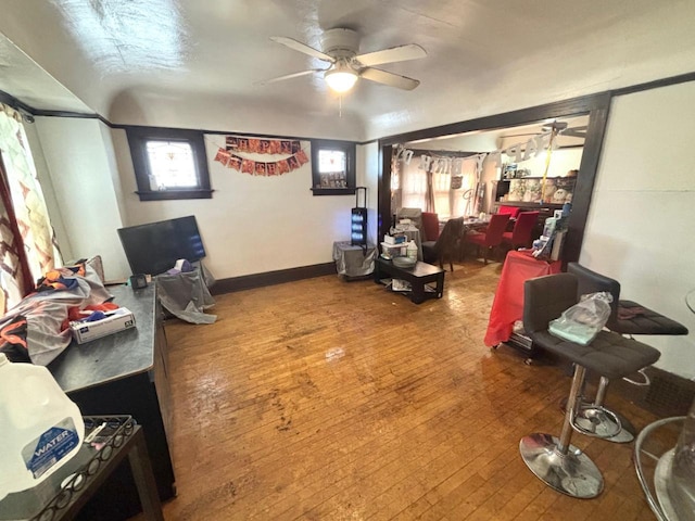 interior space featuring baseboards, a ceiling fan, and hardwood / wood-style flooring